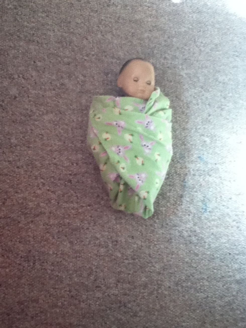 Fold the bottom right corner across the baby.