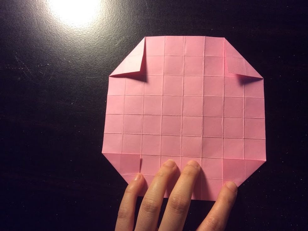 Fold the corners so you have a small triangle.