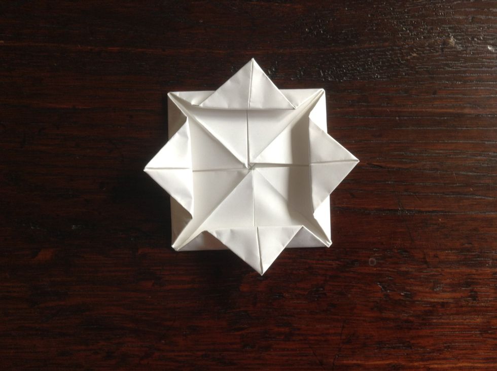 Fold the corners that are in the middle out (but not all the way) to make the first set of petals.