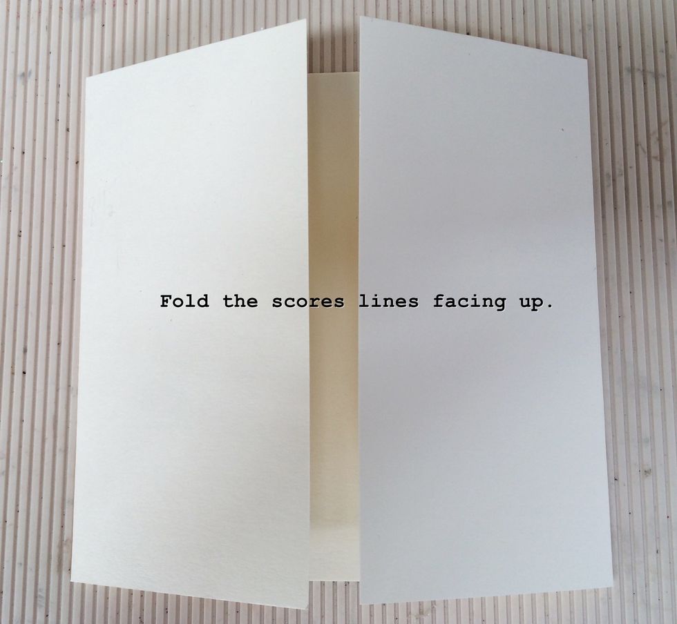 Fold the creases made on the score lines facing up.