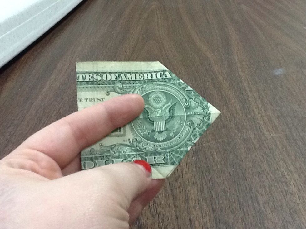 Fold the dollar in half, meeting the tips of the folds you created. Notice that the eagle kind of looks like it's doing karate. Wonder if maybe you should do karate.