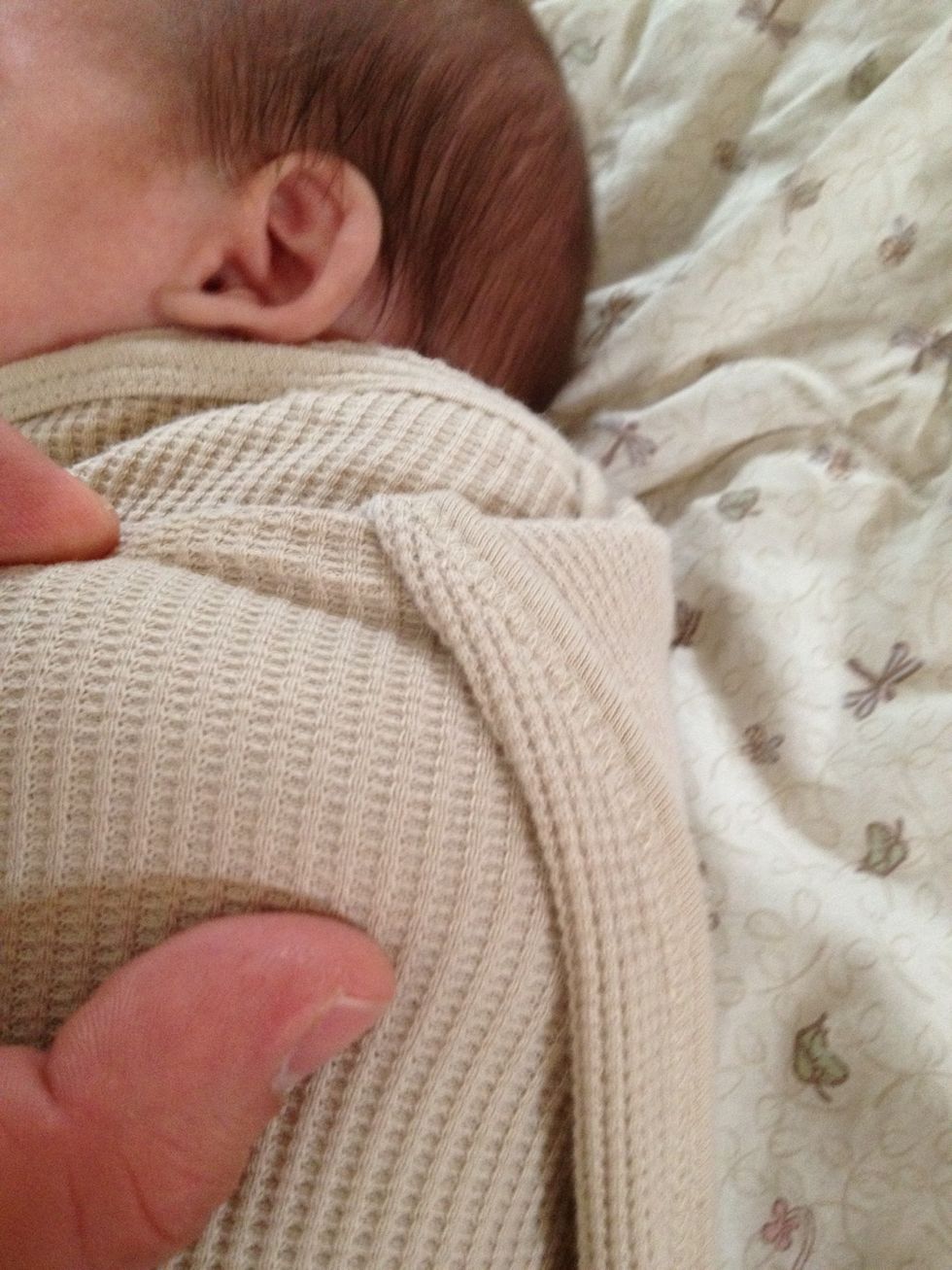 Fold the edge of the last corner you wrapped under the baby's back into a previous wrap.