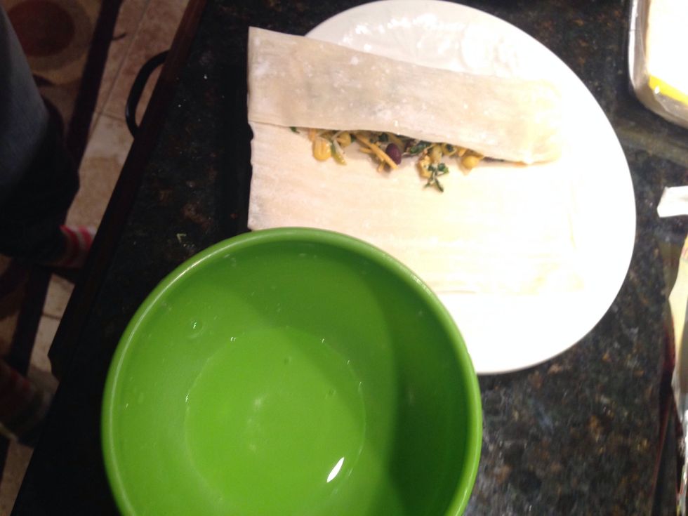 Fold the edge over. Keep a small bowl of water near where you are working.