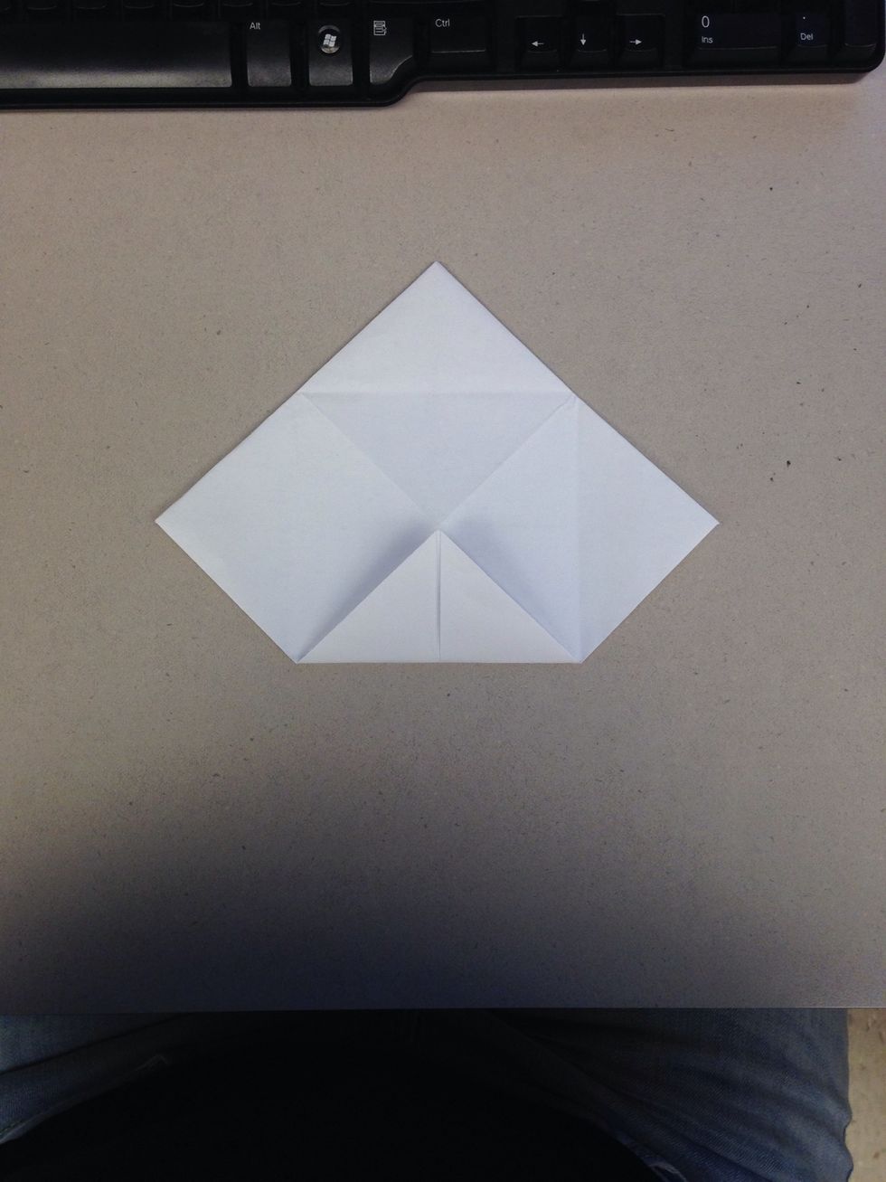 Fold the first corner into the center point, again.