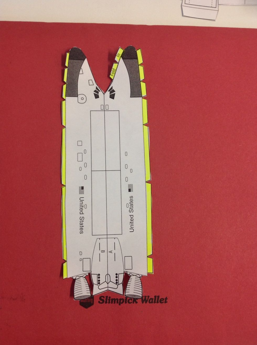 Fold the flaps (highlighted above) into the centre of the fuselage. Fold the fuselage down the centre line.