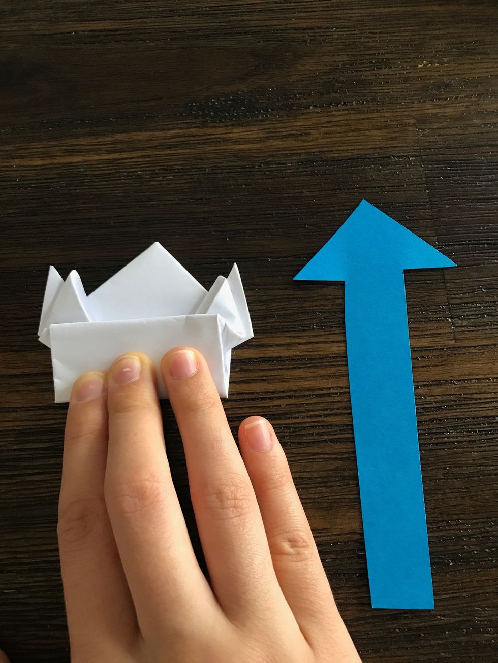 Fold the frog in half by bringing the bottom legs up.