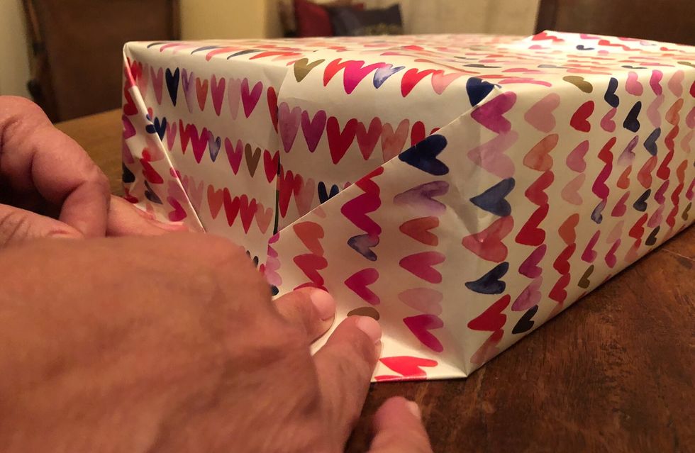 Fold the front of the paper down and crease it along the top. Then, fold each side in creating a crease on each side. Finally, fold the bottom up creating a final crease.