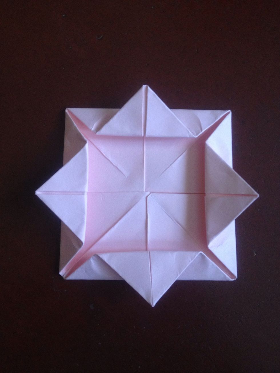 Fold the inner corners outward creasing all four flaps in half..