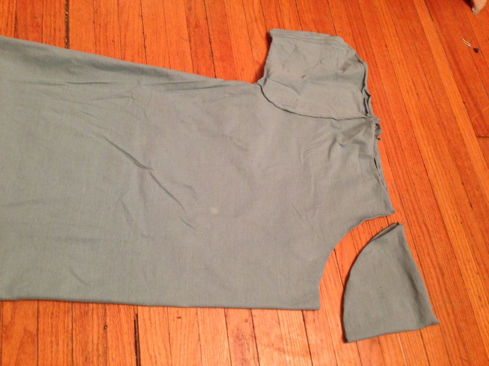 Fold the Larger T-shirt in half and cut out the curve.
