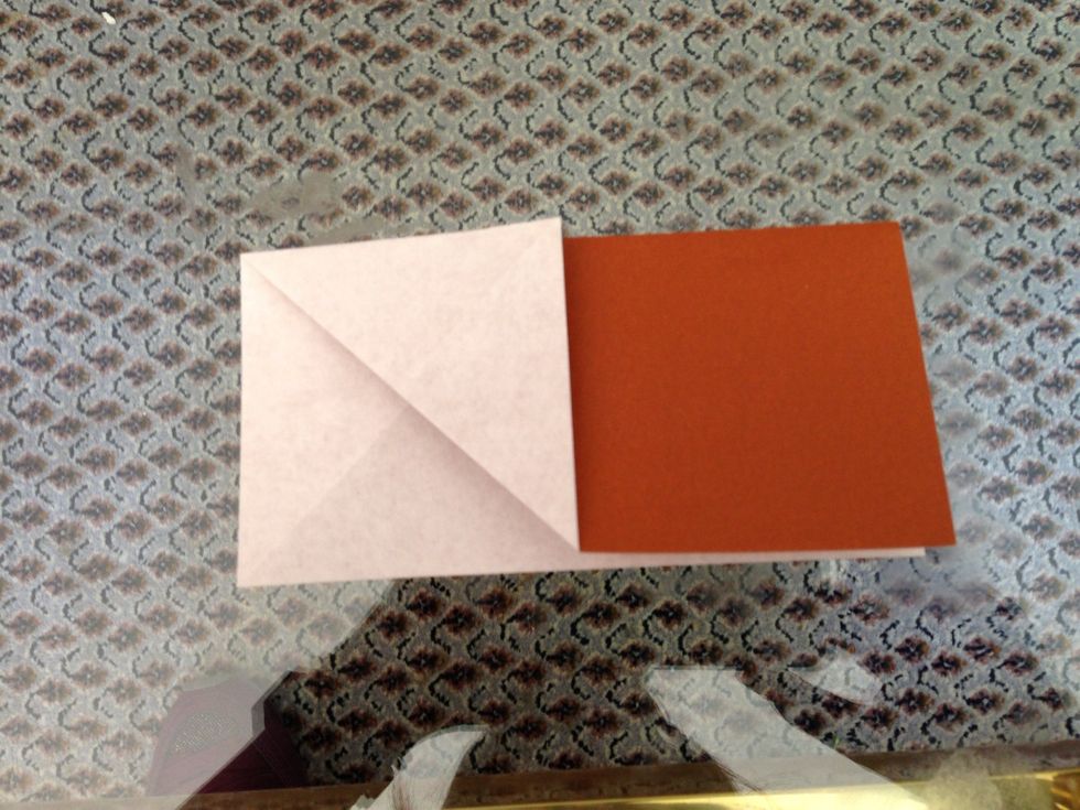 Fold the lower left corner to the folded edge at the center of the white square. Fold the white corner in the upper right of the square to the folded edge. See the next picture for the result.