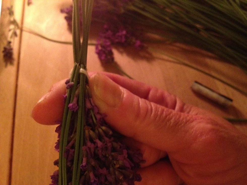 Fold the next 2 stems down under your string. Then continue to fold down 2 stems at the time alternating over and under the string.