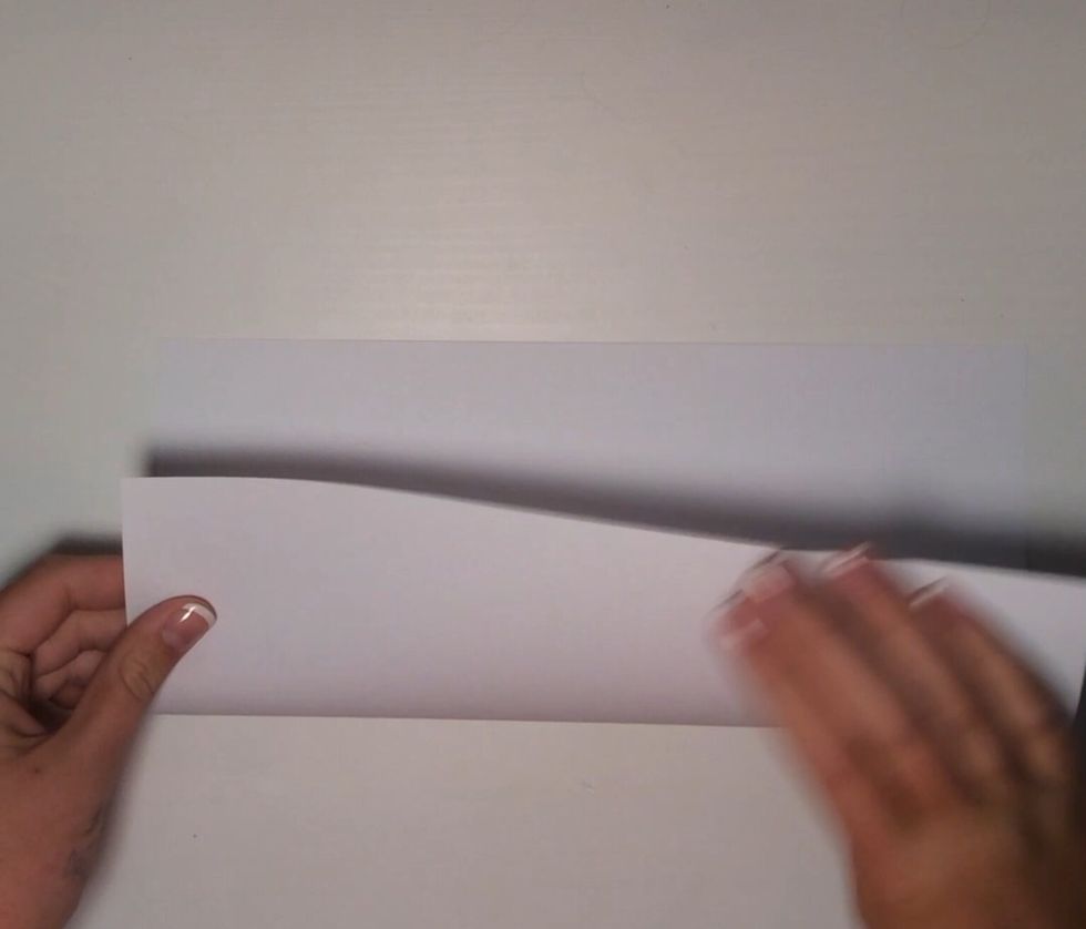 Fold the paper in half.