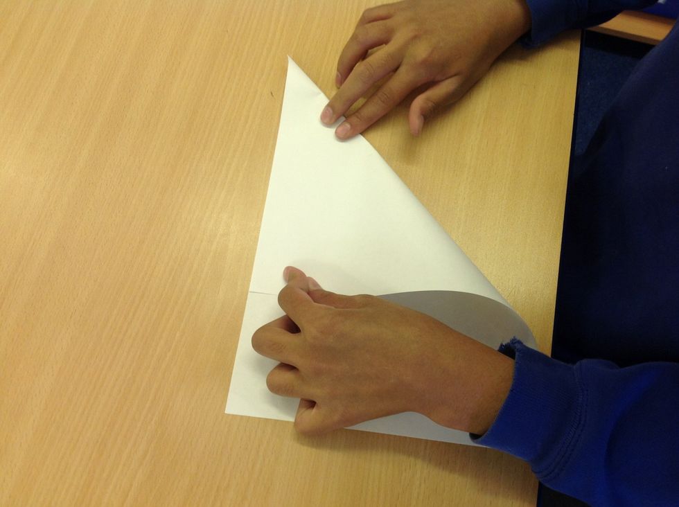 Fold the paper into a triangle so the edges meet.
