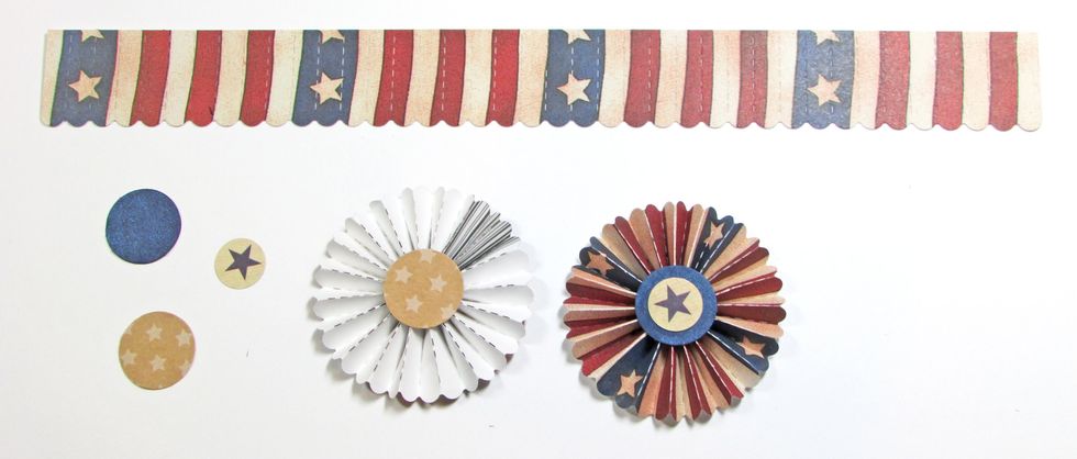 Fold the paper strip into rosette shapes and glue. Glue kraft circles to the back and blue circles to the front of each rosette. Punch three 1/2" circles from patriotic paper and glue in place.