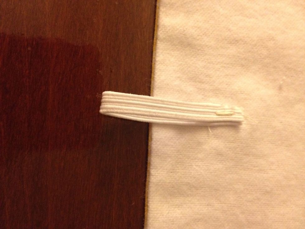 Fold the piece of elastic in half and sew to the underside of the flap