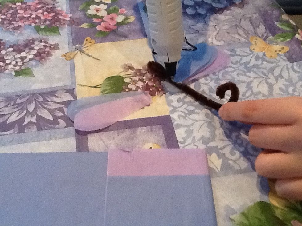 Fold the pipe cleaner in half and twist it but leave the end open in a little hoop to make a sort of head, then cut the tissue paper into wings and glue them on the body.