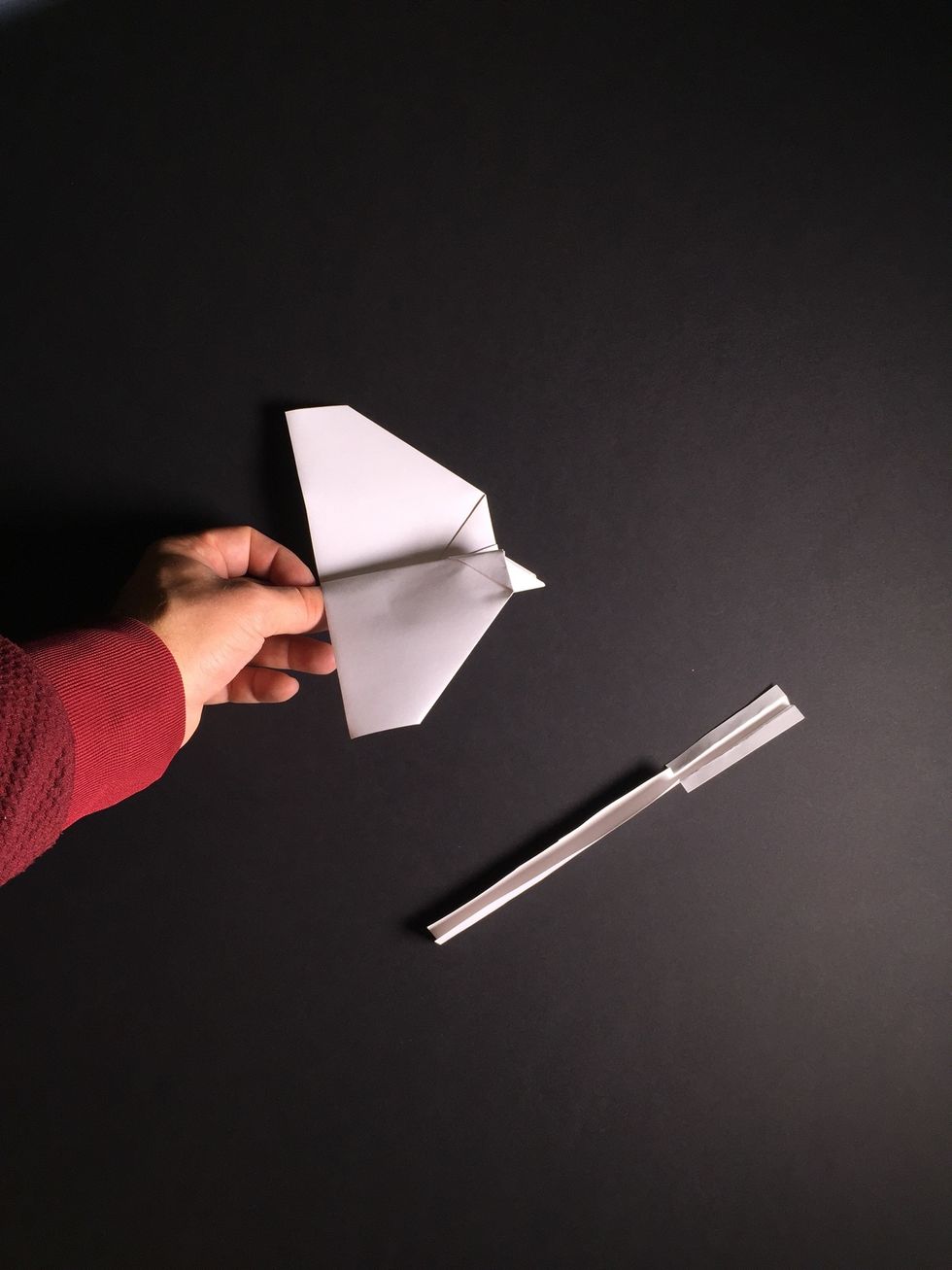 Fold the right wing down as shown in photos 26 and 27. Take special care to angle this fold in such a way so that the leading edge of the wing is slightly higher than the trailing edge.