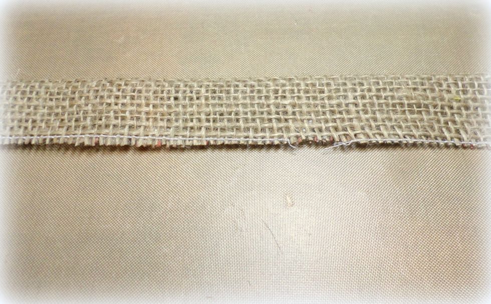 Fold the side of the burlap strip with no adhesive to the adhesive side. You get a folded strip.