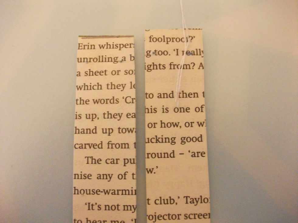 Fold the thread in half and place the loop of the thread in the middle of one strip. I would say maybe 1-2 cm.