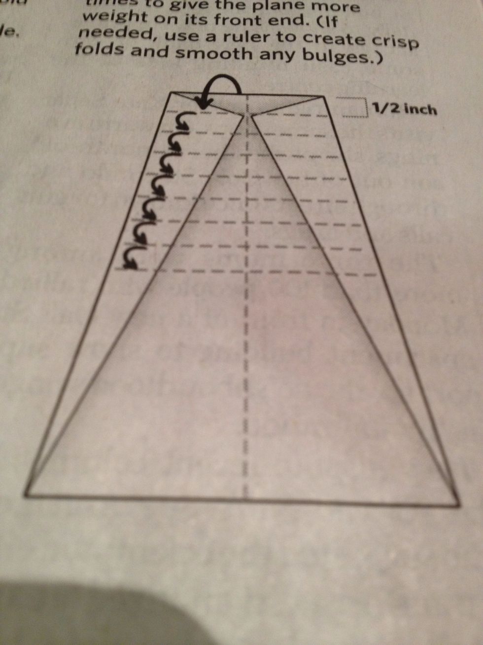 Fold the top down evenly, about a half an inch. Repeat about 8 or 9 times to give the plane more weight in its front end. (if needed, use a ruler to create crisp folds and smooth any bulges).