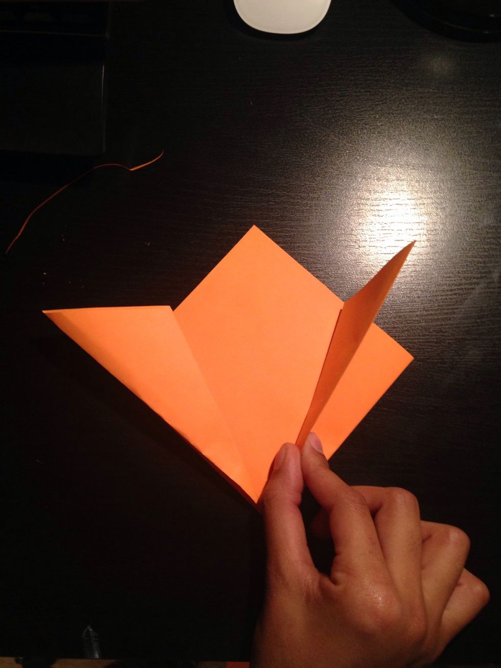 Fold the top edges of the paper downward so they align with the back of the paper.