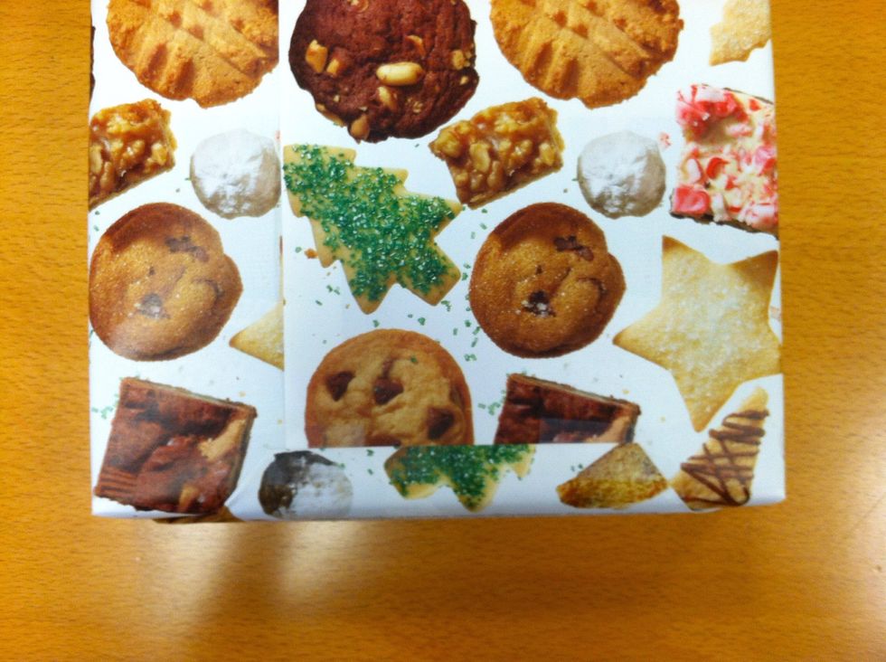 Fold the top flap down and secure with tape. Fold the bottom flap up over the top and secure with tape. Repeat on other side of present.