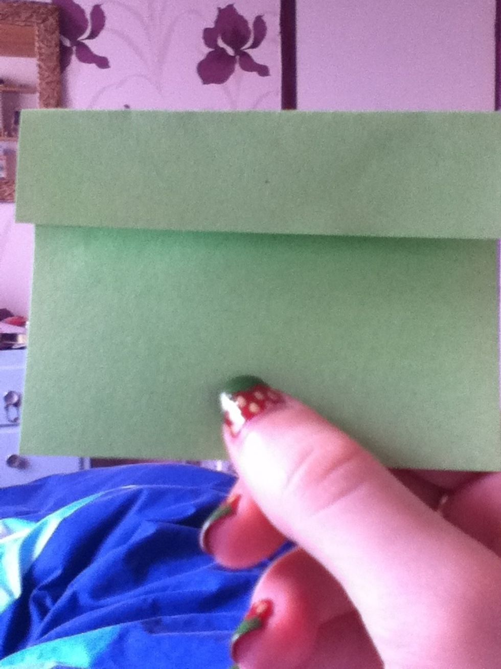 Fold the top half of the paper down to the crease, then do the same to the bottom half.