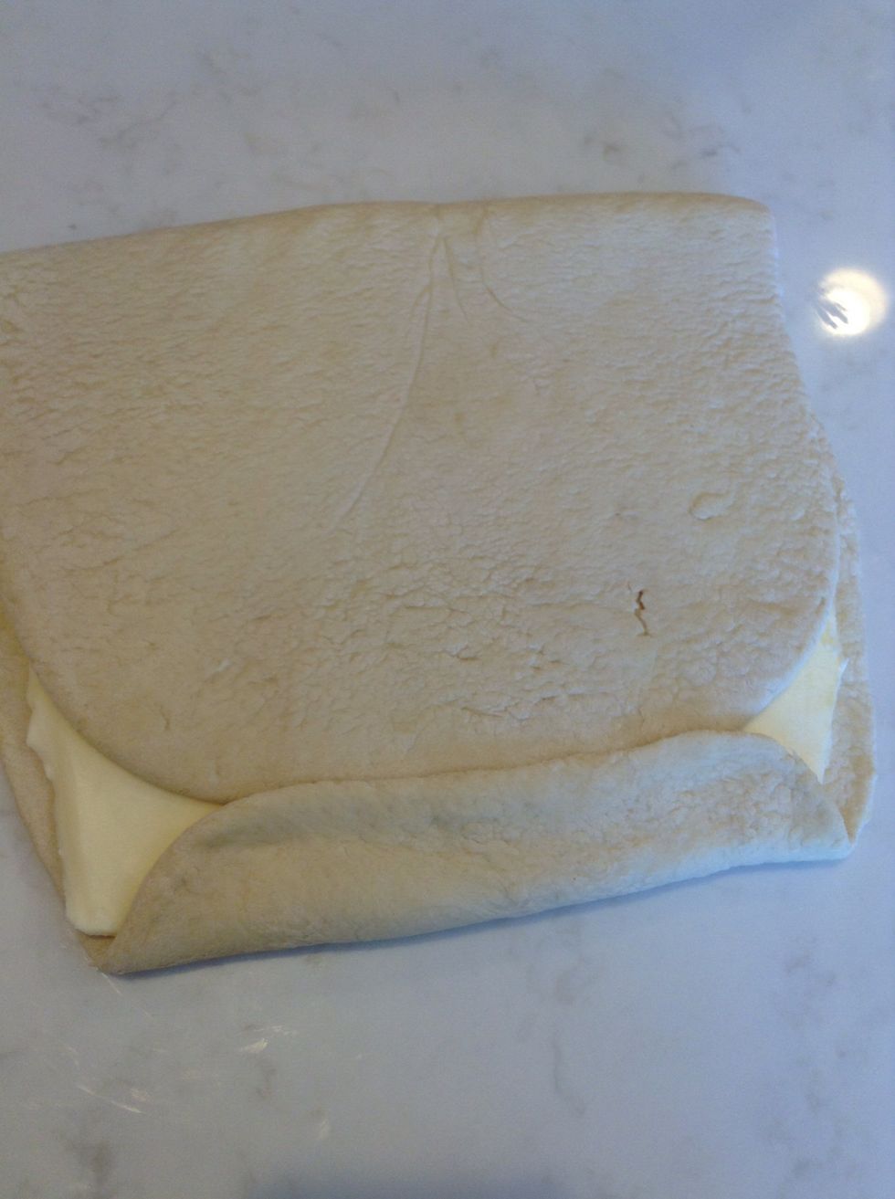 Fold the top half of the rectangle down over the butter and bottom half. Press together the edges of the dough. I should almost be completely sealed in the dough.