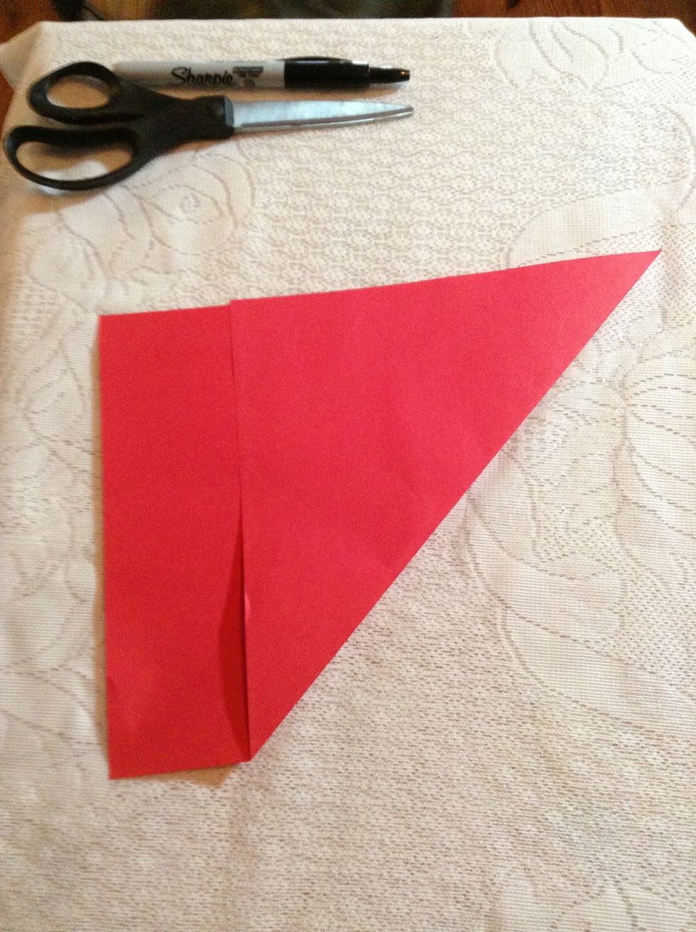 Fold the top left or right corner diagonally down as far as it will go to the opposite edge of the paper to make a triangle.