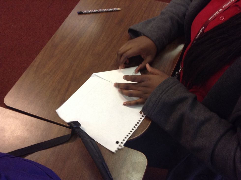 Fold the top right corner down the middle and then you fold the left corner