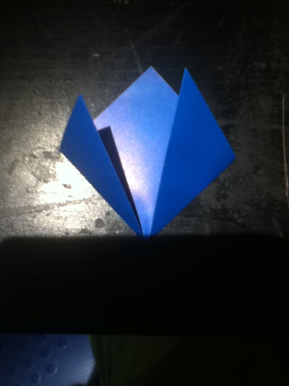 Fold the triangle's points up to the center point, forming a square.