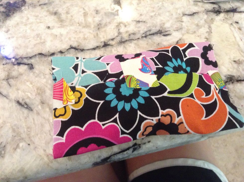 Fold the two ends that are Parallel to each other in, and cut three pieces of duct tape and put them on like shown above