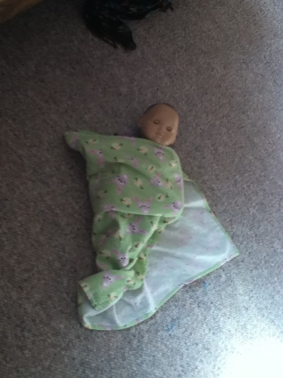 Fold the upper left corner across the baby.