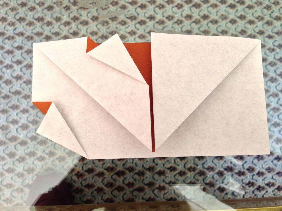 Fold the upper left corner behind on the diagonal. Fold the lower right corner behind on the diagonal too. Now turn the paper over.