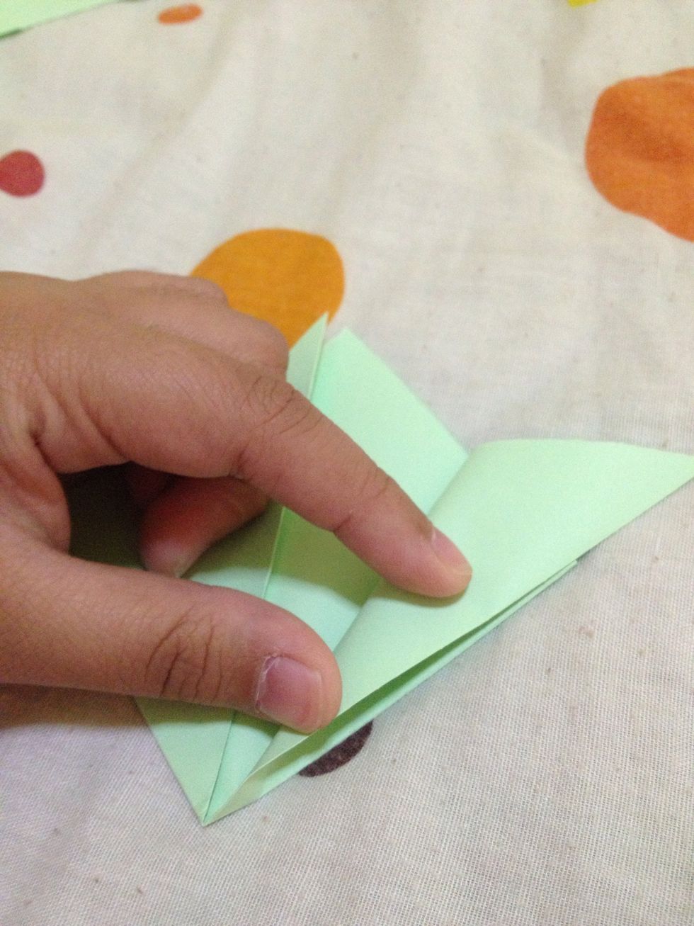 Fold this corner outward, make this edge meet to the other edge. Do the same to the other side.