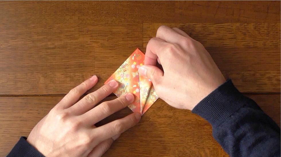 Fold top raw edges to the center crease.  Fold top corner down along folded egdes and unfold.
