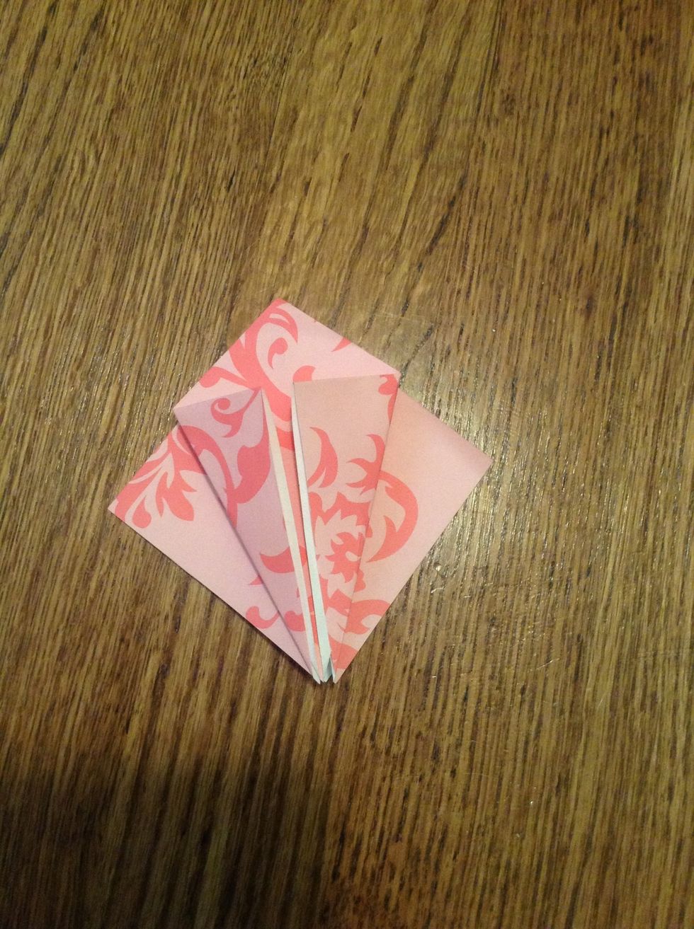 Fold top two flaps into the middle. The open side at the bottom.(no creases at the bottom of the paper when holding the paper upright.) Flip over and do the same thing again.