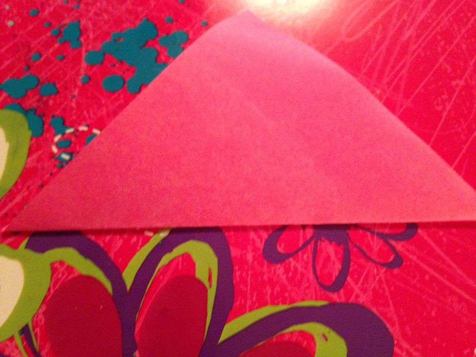 Fold up the bottom corner to make it shaped like a triangle