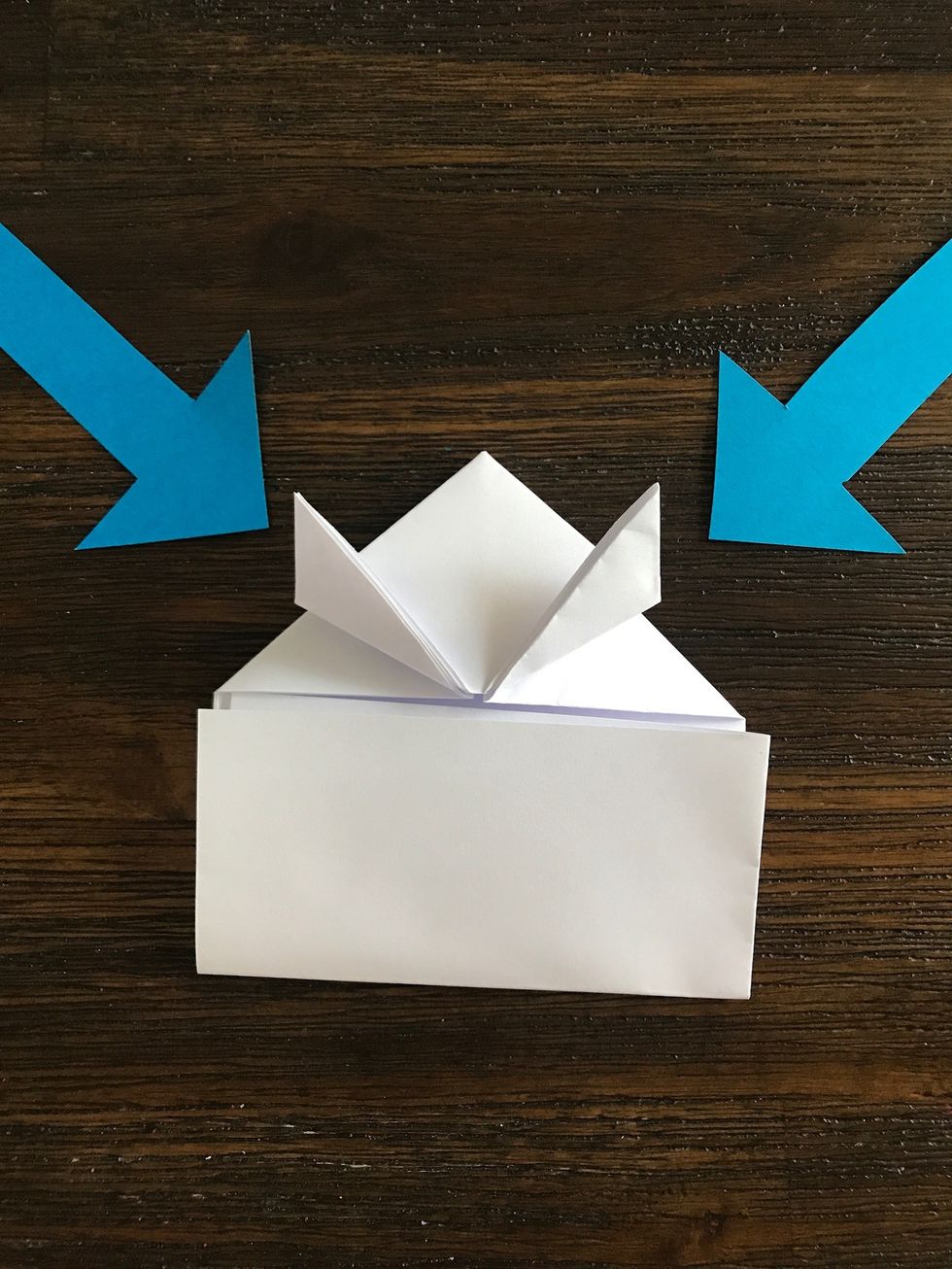 Fold up the corners of the triangle on an angle as pictured.