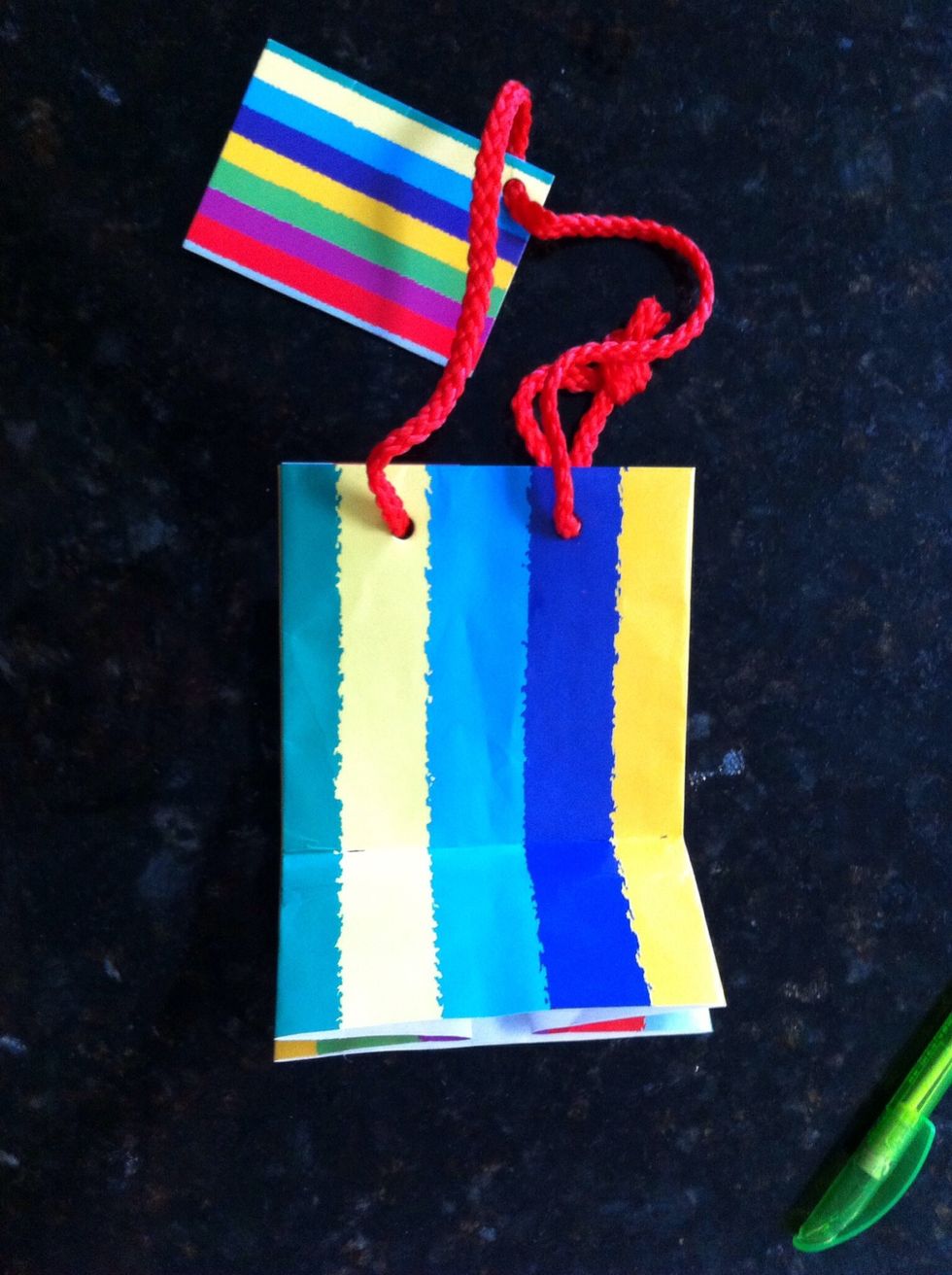 Fold up the cut edge of the bag at the half width mark (5cm in this example) then fold back to crease the paper well.