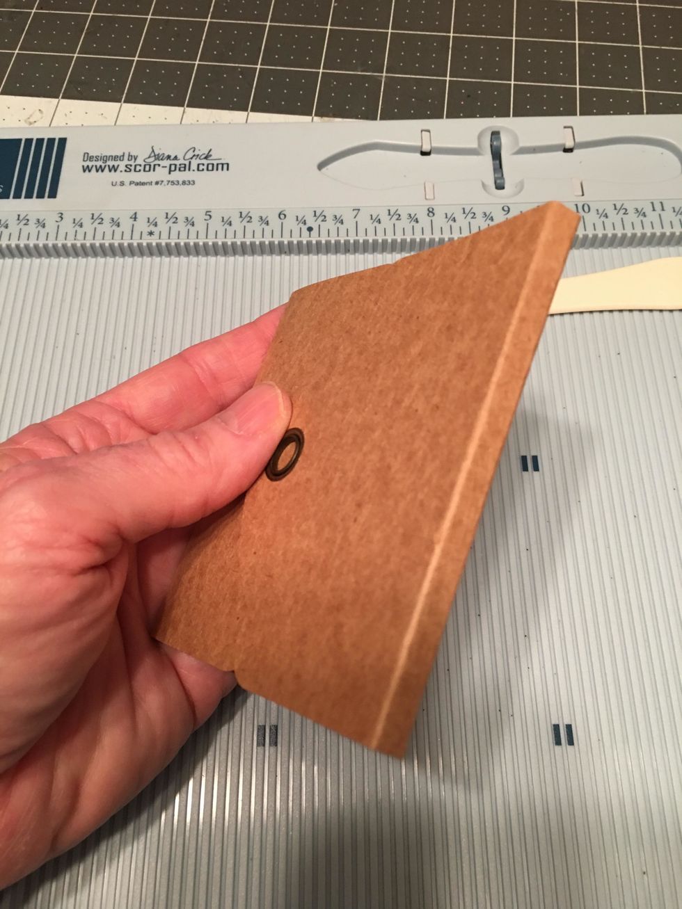 Fold up the score lines so that the finished grommet is on the outside. The 1/4" space will become the folded edge of the album.