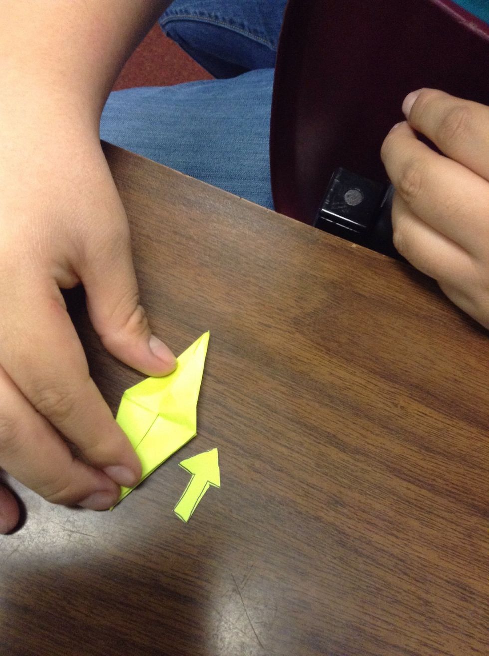 Fold up the two triangles revealing two separated triangles that look like little legs. Then flip it over and repeat.