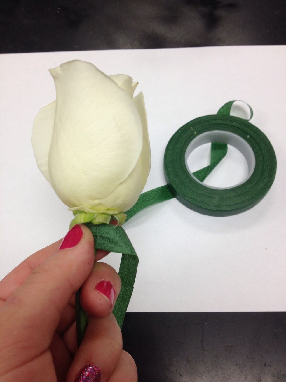 Fold wire along sides of the stem and begin to floral tape, starting at the very top of the flower.