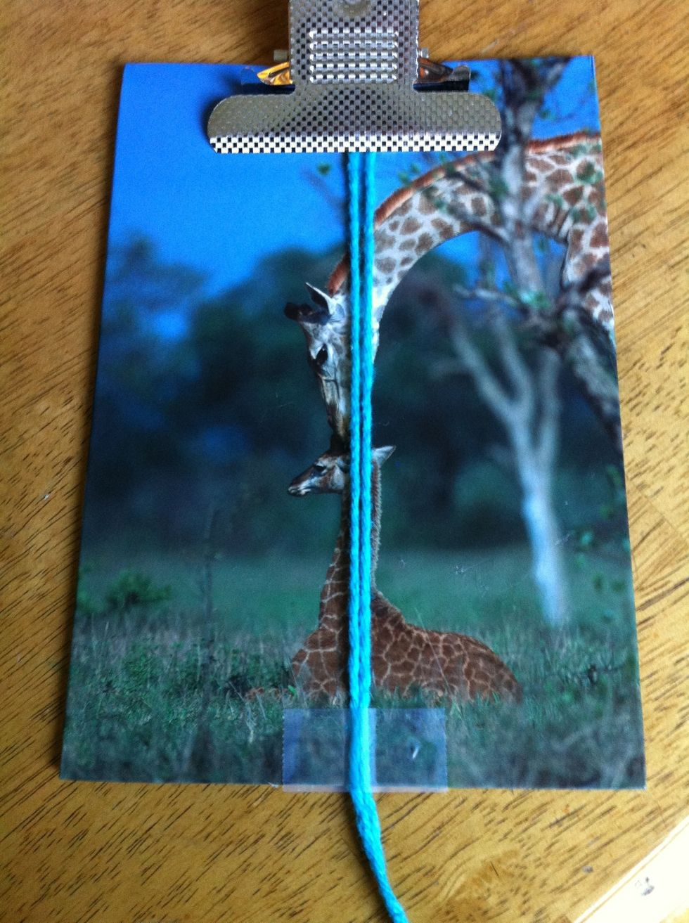 Fold your base (4ft) yarn in half. Tape the looped end down or attach it to your clipboard and then tape the other end down.