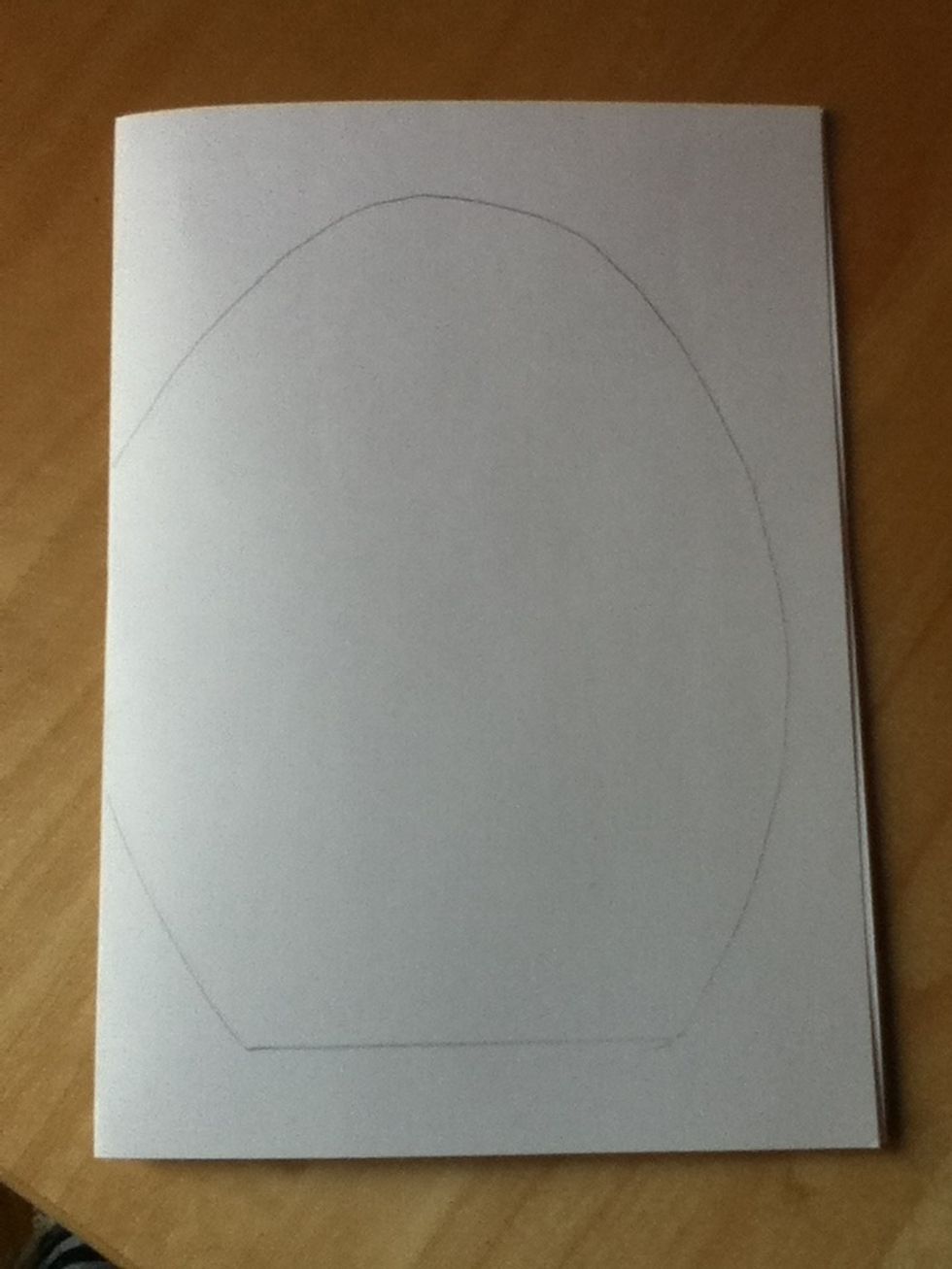 Fold your card in half and then draw an egg shape on it that has a flat bottom and one side touches the fold in the card.