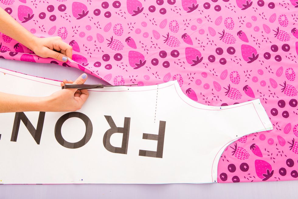 Fold your fabric in half and pin the straight edge of the pattern to the fold of the fabric. Then cut out the dress pattern that fits your size. Cut out both front and back pieces of the dress.