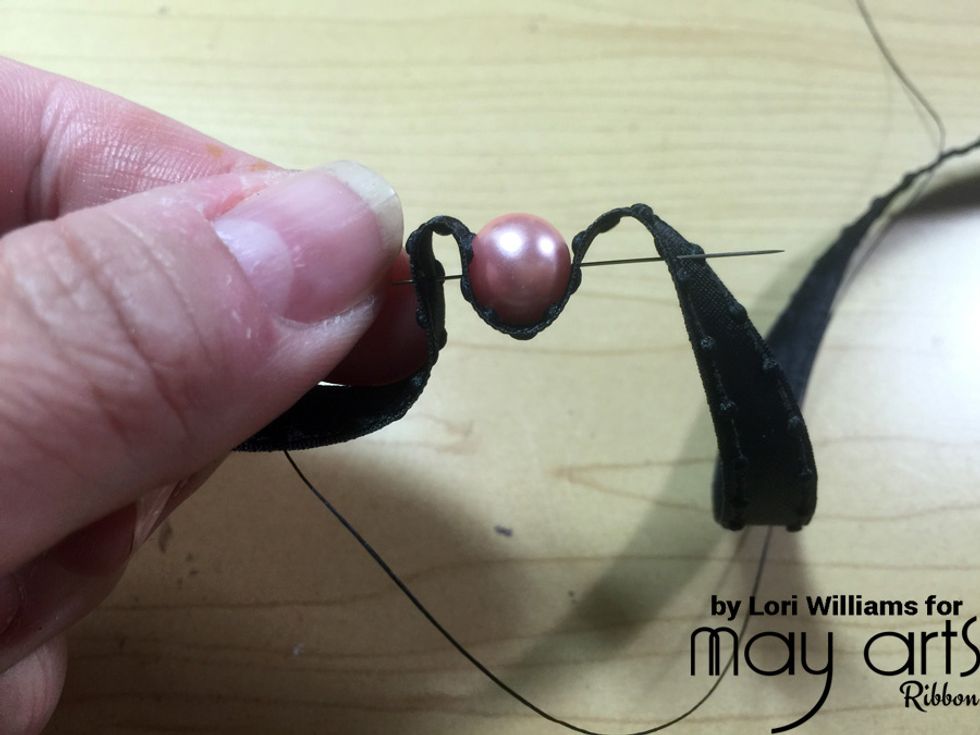 Fold your ribbon with a small hill(about \u00bc\u201d to \u00bd\u201d depending on the side of your pearl) and lay your pearl beside it, then run your needle and thread through to set.