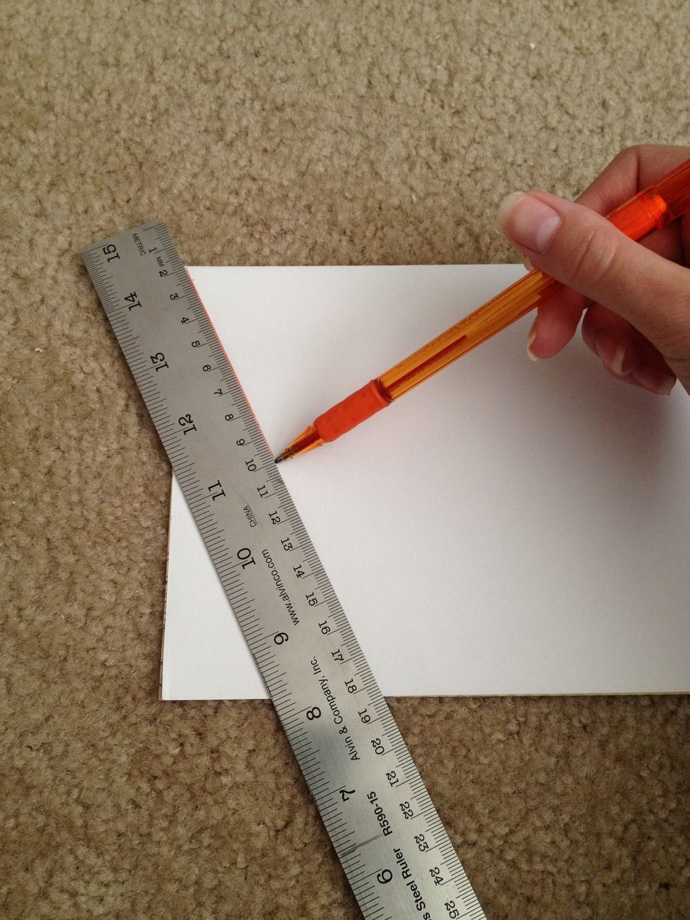 Fold your sheet of scrapbook paper in half. Place the ruler diagonally to trace a line that will make a triangle.