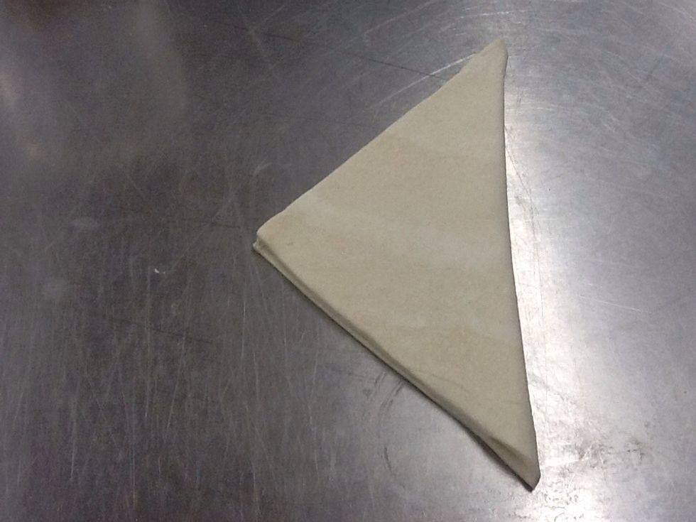 Fold your square of puff pastry in half to form a triangle shape.