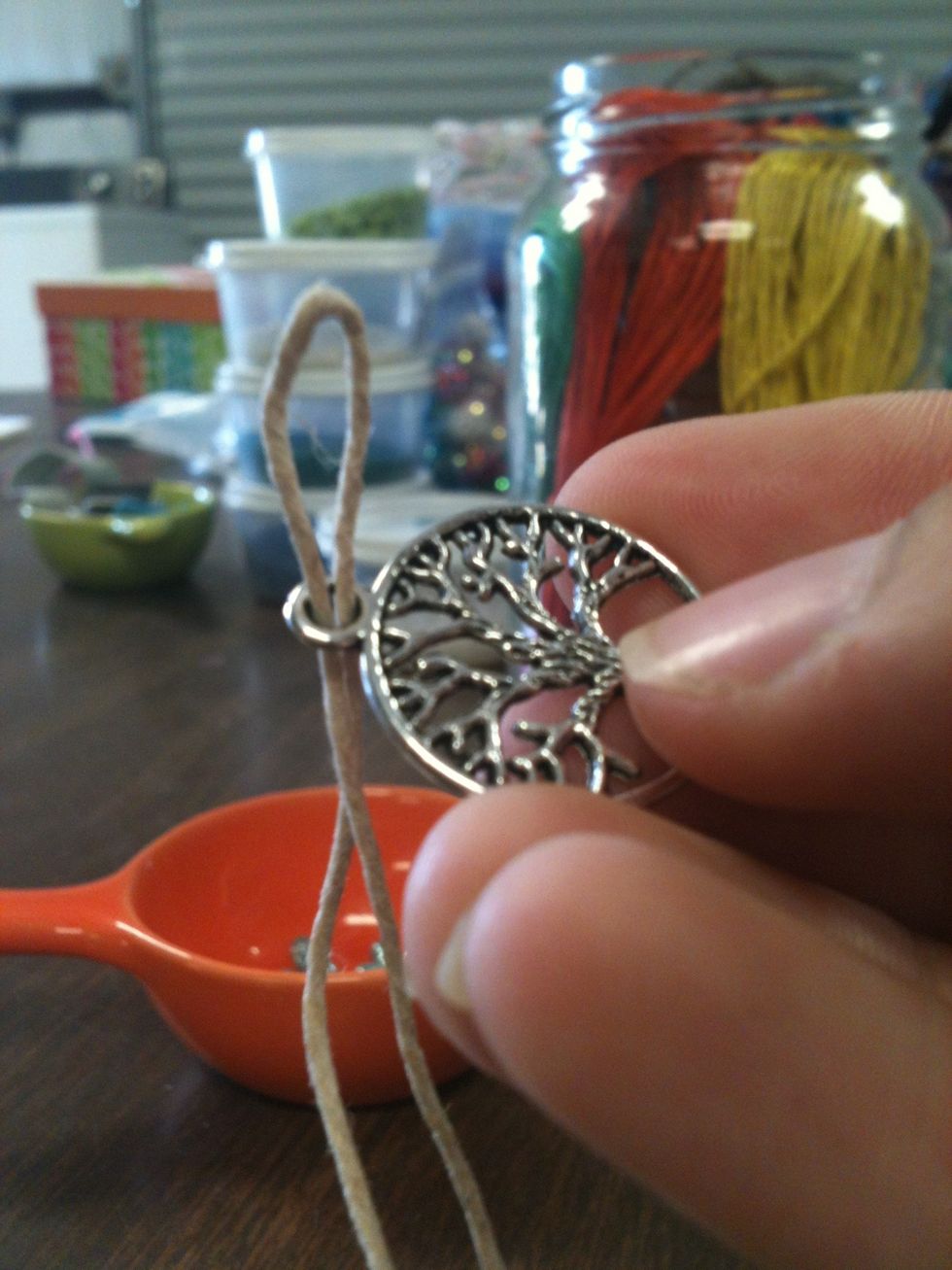 Fold your string in half and stick it through the pendant like this.
